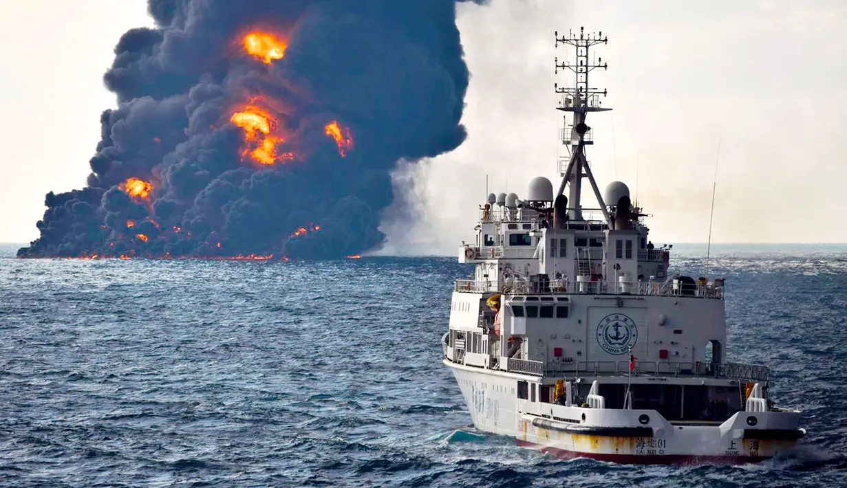 Sebuah kapal penyelamat berlayar di dekat kapal tanker minyak Iran yang terbakar di Laut Cina Timur (14/1). Kapal tanker nahas tersebut sedang berlayar menuju Korea Selatan sebelum bertabrakan dengan sebuah kapal kargo. (Ministry of Transport via AP)