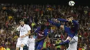 Bek Barcelona, Gerard Pique, membuang bola dari jangkauan pemain Real Madrid pada laga La Liga Spanyol di Stadion Camp Nou, Barcelona, Minggu (6/5/2018). Kedua klub bermain imbang 2-2. (AFP/Pau Barrena)