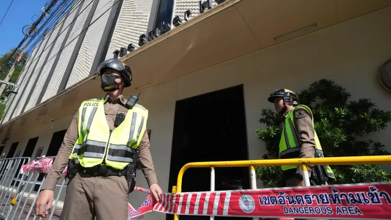 Polisi berjaga di depan hotel yang mengalami kebakaran di Bangkok, Thailand. (Sakchai Lalit/AP)