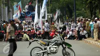 Ribuan guru honorer dari berbagai wilayah duduk di ruas jalan Asia Afrika Jakarta, Selasa (15/9/2015). Aksi para guru honorer terpaksa dihentikan oleh pihak kepolisian karena mengganggu pengguna jalan. (Liputan6.com/Helmi Fithriansyah)