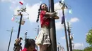 Salah satu wisatawan asing terlihat antusias mengikuti lomba panjat pinang kolosal yang diadakan untuk merayakan HUT ke-80 Kemerdekaan Indonesia, di Pantai Ancol, Jakarta, Minggu 17 Agustus 2025. (AP Photo/Tatan Syuflana)