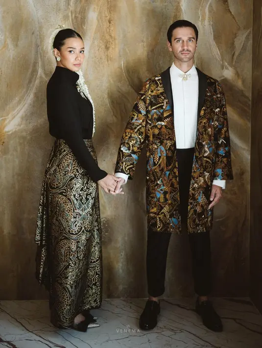 Potret pre-wedding bertema pengantin Jawa tak sampai di situ saja. Adinia kali ini mengenakan atasan lengan panjang berwarna hitam, dilengkapi bros emas, dan dipadu kain batik sebagai bawahan. Rambutnya ditata sleek look, diberi pemanis hiasan bunga melati. Sedangkan Michael tampil dengan atasan berwarna putih, ditumpuk dengan outer batik, dan dipadu celana panjang hitam. Foto: Instagram.