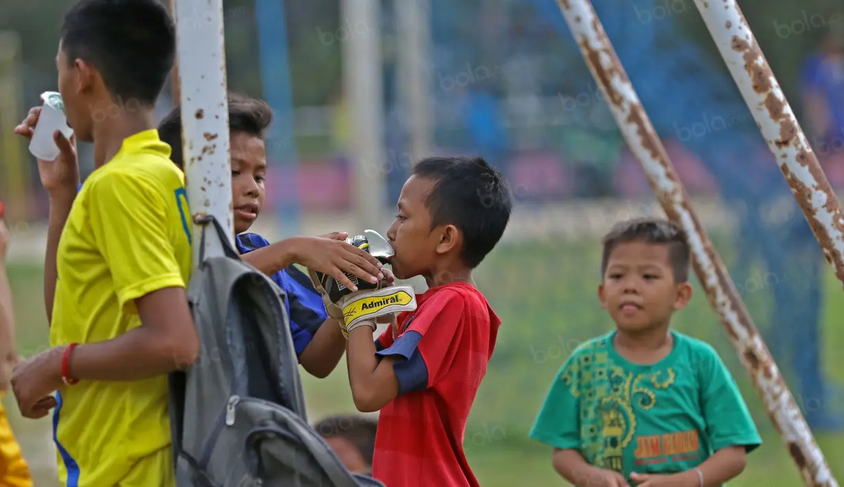 Cara melepas dahaga anak-anak SSB PS TAL Sawahlunto saat berlatih di Stadion Tanah Lapang Ombilin, Sawahlunto, (8/11/2016). (Bola.com/Nicklas Hanoatubun)
