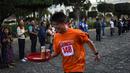 Seorang pramusaji beradu kecepatan sambil membawa nampan dalam Waiters Race ke-16 di Antigua, barat daya Ibu Kota Guatemala City, Rabu (14/11). Lomba ini diikuti oleh ratusan peserta yang merupakan pelayan restoran dan kafe setempat. (JOHAN ORDONEZ/AFP)