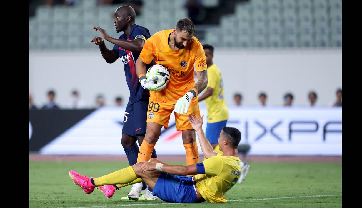 Penjaga gawang PSG, Gianluigi Donnarumma (tengah), membantu berdiri pemain Al Nassr, Cristiano Ronaldo, setelah keduanya berebut bola di udara dalam pertandingan uji coba yang berlangsung di Nagai Stadium, Osaka, Selasa (25/7/2023). (AFP/Paul Miller)