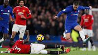 Gelandang Chelsea, Eden Hazard berusaha melewati bek MU, Eric Bailly saat bertanding pada lanjutan Liga Inggris di Stamford Bridge di London (5/11). Chelsea Menang tipis atas MU 1-0. (AP Photo/Kirsty Wigglesworth)