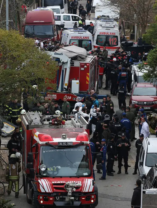 Regu penyelamat berada di lokasi jatuhnya helikopter militer di lingkungan perumahan di Istanbul, Turki, Senin (26/11). Helikopter dalam penerbangan latihan ketika menabrak atap gedung dan jatuh di tengah daerah perumahan Sancaktepe. (AP/Emrah Gurel)