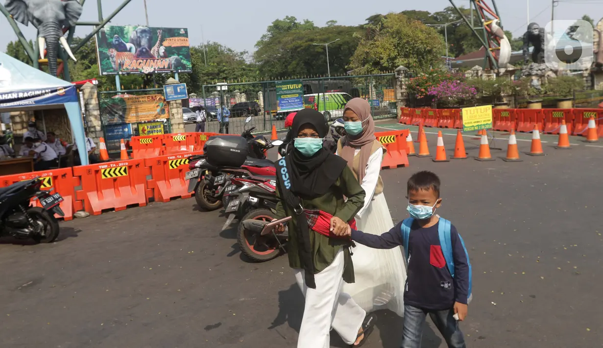 Calon pengunjung melintas di depan gerbang utama kawasan Kebun Binatang Ragunan, Jakarta, Minggu (16/5/2021). Sejumlah kawasan wisata di DKI Jakarta ditutup sementara untuk umum hingga 18 Mei 2021 untuk pemberlakukan penguatan protokol kesehatan COVID-19. (Liputan6.com/Helmi Fithriansyah)