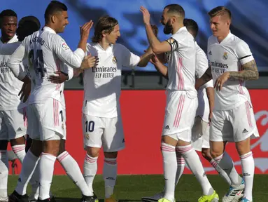 Para pemain Real Madrid merayakan gol yang dicetak oleh Karim Benzema ke gawang Valencia pada laga Liga Spanyol di Stadion Alfredo Di Stefano, Minggu (14/2/2021). Real Madrid menang dengan skor 2-0. (AP/Manu Fernandez)