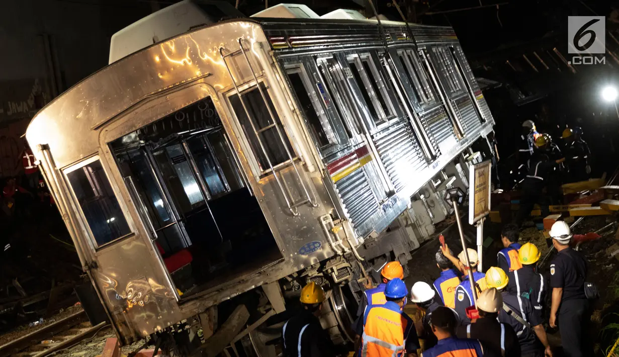 Petugas dibantu alat berat mengevakuasi gerbong KRL Commuter Line jurusan Jatinegara - Bogor di kawasan Kebon Pedes, Bogor, Jabar Minggu (10/3). Proses evakuasi menggunakan crane yang didatangkan dari Bandung. (Liputan6.com/Immanuel Antonius) 