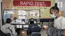 Calon penumpang mengikuti rapid test COVID-19 di Stasiun Pasar Senen, Jakarta, Senin (26/10/2020). Memasuki libur panjang, jumlah penumpang kereta jarak jauh mengalami lonjakan sehingga terjadi antrean panjang rapid test yang menjadi syarat wajib pengguna jasa KAI. (merdeka.com/Iqbal S. Nugroho)