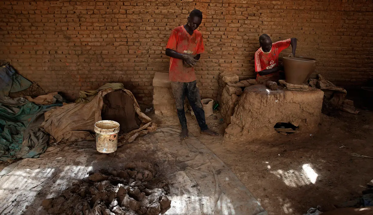 Pekerja membuat pot tanah liat di sebuah bengkel tembikar di Khartoum, Sudan, Kamis (27/6/2019). Pot tanah liat tersebut nantinya akan dipajang untuk dijual. (AP Photo/Hussein Malla)