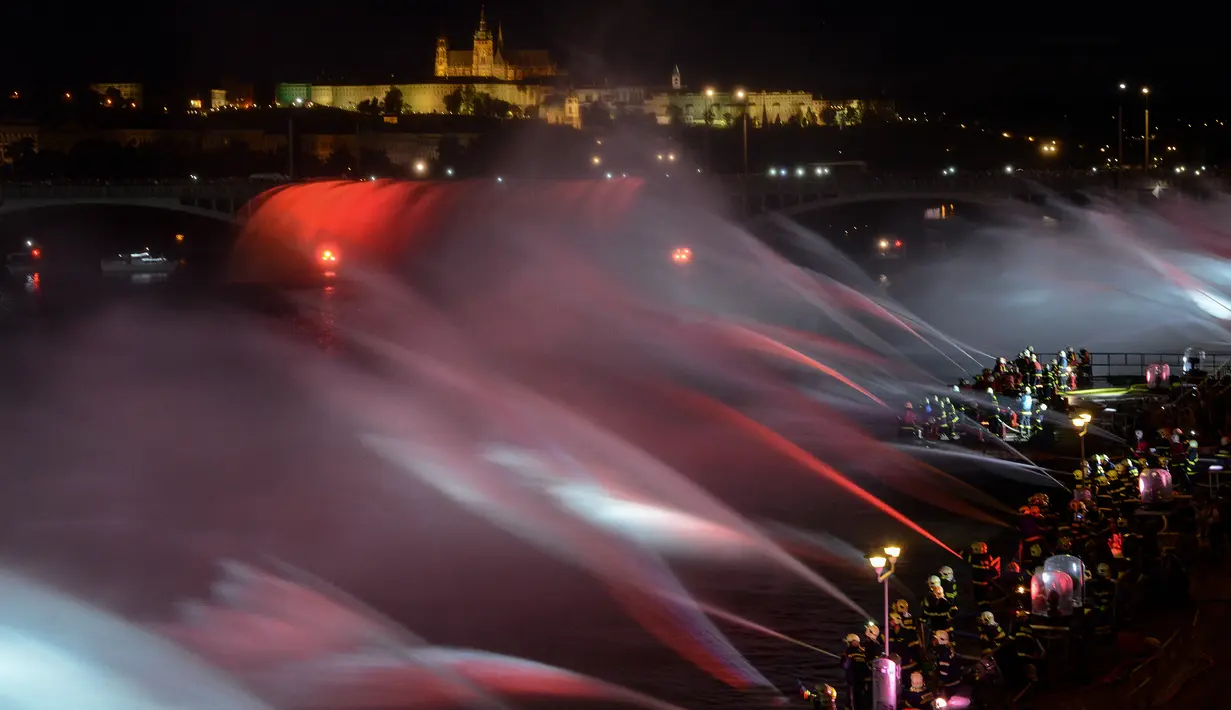 Suasana saat petugas pemadam kebakaran menyemprotkan air ke Sungai Vltava untuk menandai HUT ke-100 Ceko di Praha, Sabtu (2/6). (Michal Cizek/AFP)