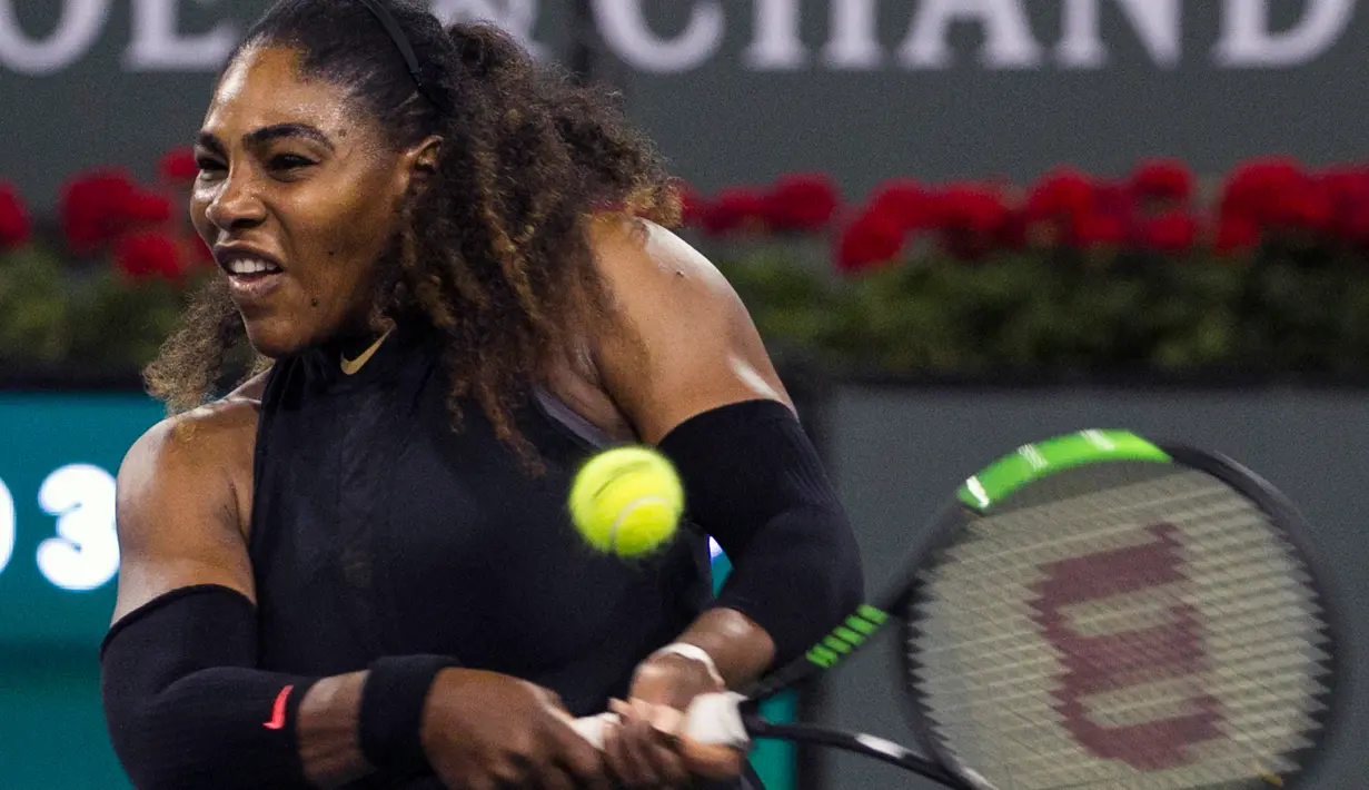 Serena Williams memukul bola saat melawan Venus Williams dalam turnamen BNP Paribas Open di Indian Wells Tennis Garden, California (12/3). Serena Williams kalah dari kakaknya, Venus Williams dengan skor 6-3, 6-4. (AP Photo/Crystal Chatham)