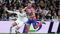 Pemain depan Real Madrid asal Prancis #09 Kylian Mbappe ditarik oleh bek Atletico Madrid asal Prancis #15 Clement Lenglet selama pertandingan sepak bola liga Spanyol antara Real Madrid vs Atletico Madrid di Stadion Santiago Bernabeu pada Minggu, 9 Februari 2025 dini hari WIB. (Thomas COEX / AFP)