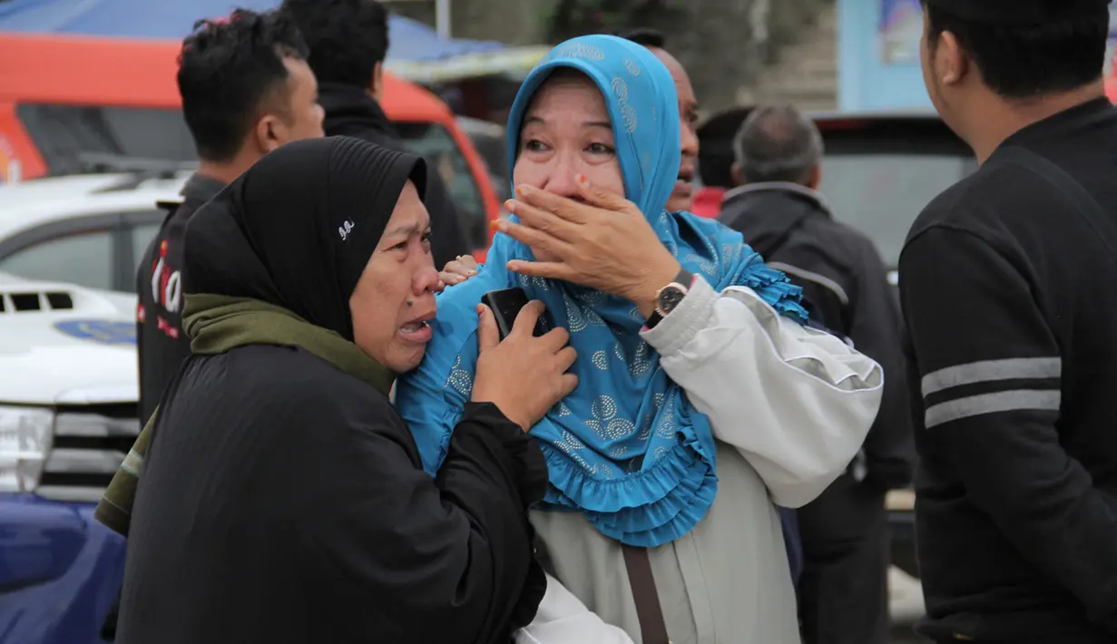 Warga menangis saat mengetahui keluarganya menjadi korban hilang kapal tenggelam di Danau Toba, Sumatera Utara, Selasa (19/6). Selain kelebihan muatan, tenggelamnya KM Sinar Bangun diperparah dengan angin kencang dan ombak besar. (AP Photo/Lazuardy Fahmi)
