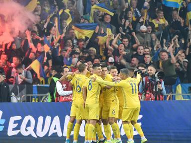 Para pemain Ukraina merayakan gol yang dicetak Andriy Yarmolenko ke gawang Portugal pada laga Kualifikasi Piala Eropa 2020 di Stadion NSK Olimpiyskyi, Kiev, Senin (14/10). Ukraina menang 2-1 atas Portugal. (AFP/Genya Savilov)