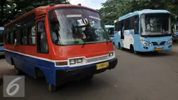 Kopaja melintas disamping  Kopaja terintegrasi Transjakarta yang terparkir di Parkir Timur Senayan, Jakarta, Selasa (22/12). Rute yang terintegrasi dengan koridor IV Dukuh Atas-Pulogadung, koridor V Ancol-Kampung Melayu. (Liputan6.com/Johan Tallo)