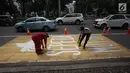 Pekerja menyelesaikan pengecatan rambu jalur kuning khusus sepeda motor di Jalan Medan Merdeka, Jakarta, Selasa (16/1).  Dishub DKI akan menguji coba dengan jalur khusus motor di kawasan itu untuk dievaluasi dalam dua minggu. (Liputan6.com/Arya Manggala)