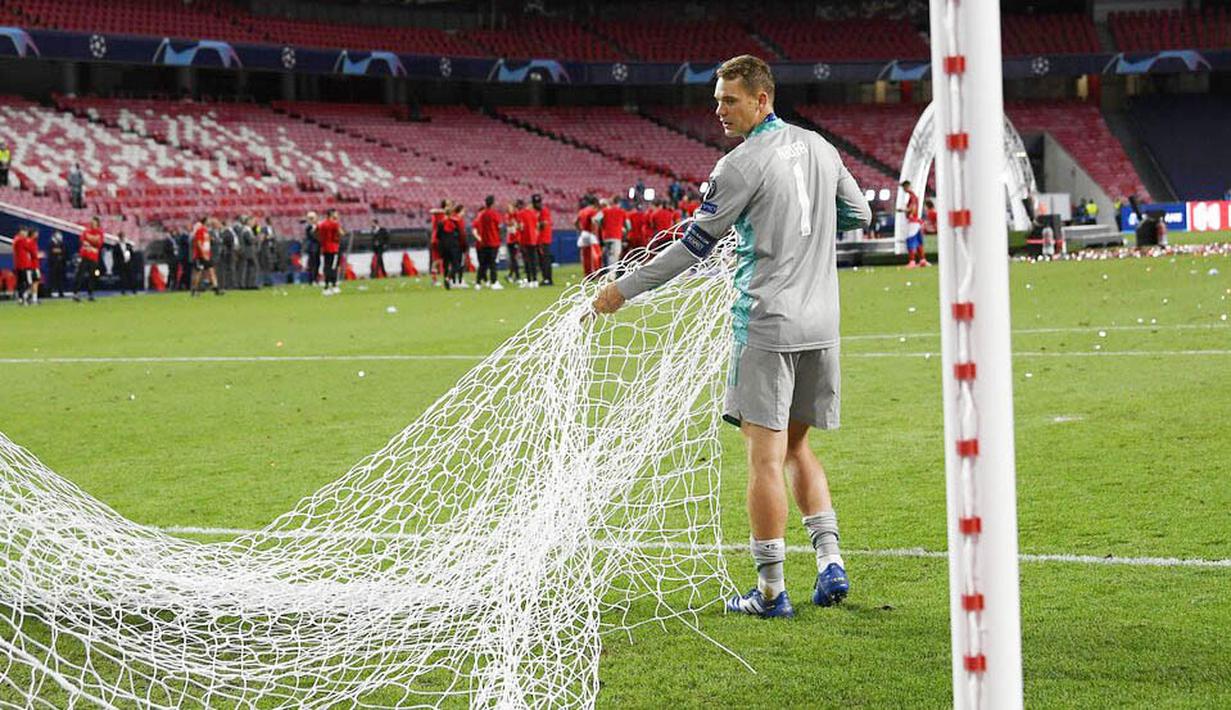 Kiper Bayern Munchen, Manuel Neuer, membawa jaring gawang usai menjuarai Liga Champions di Stadion The Luz, Portugal, Senin (24/8/2020). Bayern Munchen berhasil menjadi juara usai menaklukkan PSG 1-0. (Lluis Gene/ Pool via AP)