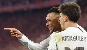 Penyerang Real Madrid, Kylian Mbappé (kiri), merayakan gol yang membawa skor menjadi 2-3 bersama rekan setimnya, Arda Guler, dalam pertandingan leg kedua perempat final Liga Champions 2025/2026 antara Bayern Munich dan Real Madrid di Munich, Jerman selatan, pada 15 April 2026. (Alexandra BEIER / AFP)