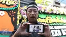 Komedian Doyok menujukkan foto Alm Eko Koeswoyo alias Eko DJ kepada wartawan kawasan Pondok Kelapa, Jakarta, Selasa (28/3). Eko DJ meninggal dunia dalam usia 65 tahun. (Liputan6.com/Herman Zakharia)