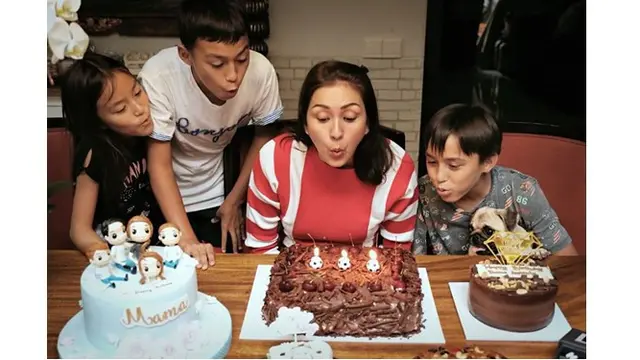 Momen Donna ditemani anak-anaknya untuk meniup lilin.