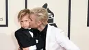 Justin Bieber mencium adiknya, Jaxon, saat berpose di karpet merah Grammy Awards 2016 di Staples Center, Los Angeles, Senin (15/2). Meski terpaut usia 15 tahun, namun Bieber  tampak dekat dengan sang adik. (Jason Merritt/Getty Images for NARAS/AFP)