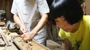 Ma Yuesi (kiri) membuat Guqin, alat musik tradisional China, di kediamannya di Desa Yalan, Distrik Yuhang, Hangzhou, Provinsi Zhejiang, China pada 30 Juni 2020. Selama bertahun-tahun, sebagai pewaris warisan budaya takbenda, Ma tak pernah berhenti meningkatkan keterampilannya. (Xinhua/Weng Xinyang)