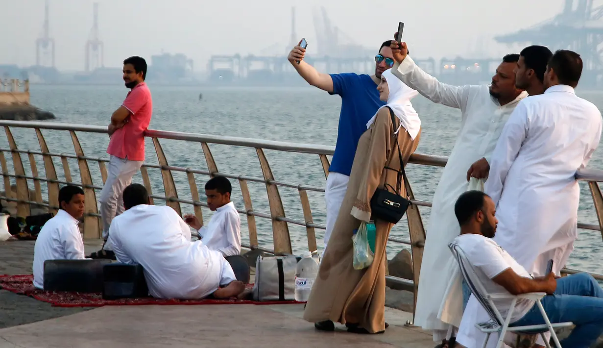 Pengunjung berswafoto saat mengunjungi Air Mancur Raja Fahd di Jeddah, Arab Saudi, Jumat (18/10/2019). Air Mancur Raja Fahd berasal dari adalah air asin yang langsung diambil dari Laut Merah. (AP Photo/Amr Nabil)