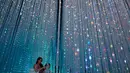 Pengunjung melintasi instalasi "Wander though the Crystal World" di Museum Seni Digital Mori Building, Tokyo, 21 Juni 2018. Selain karya seni, museum ini juga menyuguhkan area panjat dinding yang dipadukan dengan karya seni digital. (AP/Shuji Kajiyama)