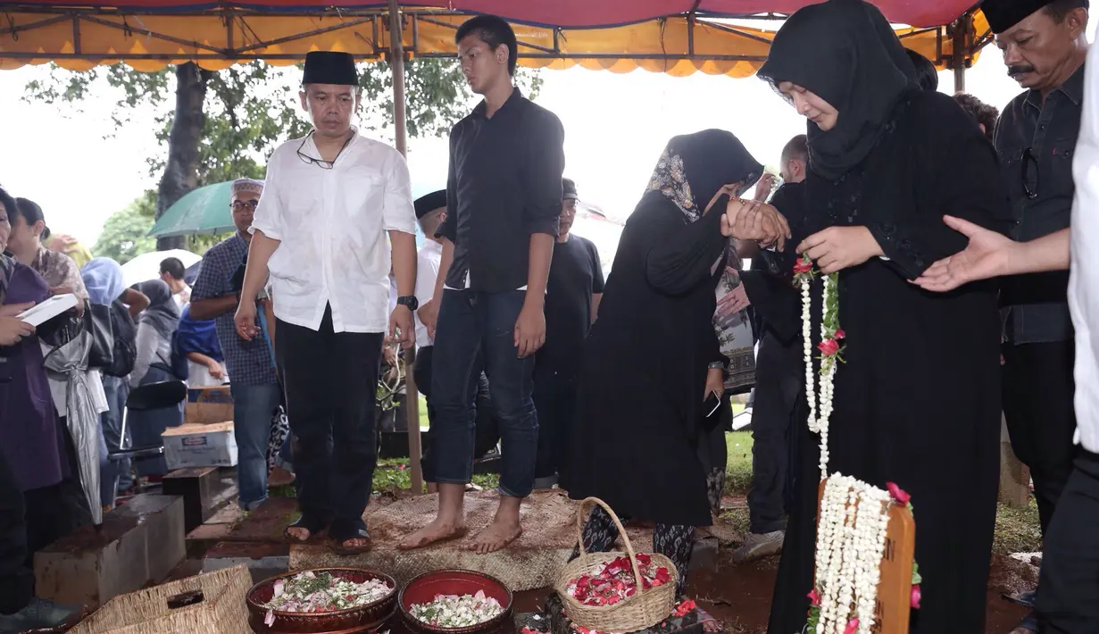 Usai pemakaman sang suami, Iga Mawarni nampak tegar. Begitu juga putranya, Rajasa Satria Tama, anak semata wayangnya. Keduanya masih bisa melemparkan senyum saat mendapat ucapan bela sungkawa. (Galih W. Satria/Bintang.com)