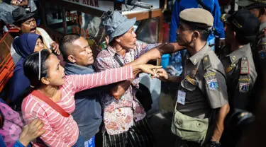 Para pedagang melawan petugas saat penertipan PKL di kawasan Stasiun Kota Tua, Jakarta, Selasa (25/10). Dalam penertipan tersebut pedagang melawan dikarenakan mereka telah membayar iuran setiap harinya  ke petugas. (Liputan6.com/Faizal Fanani)