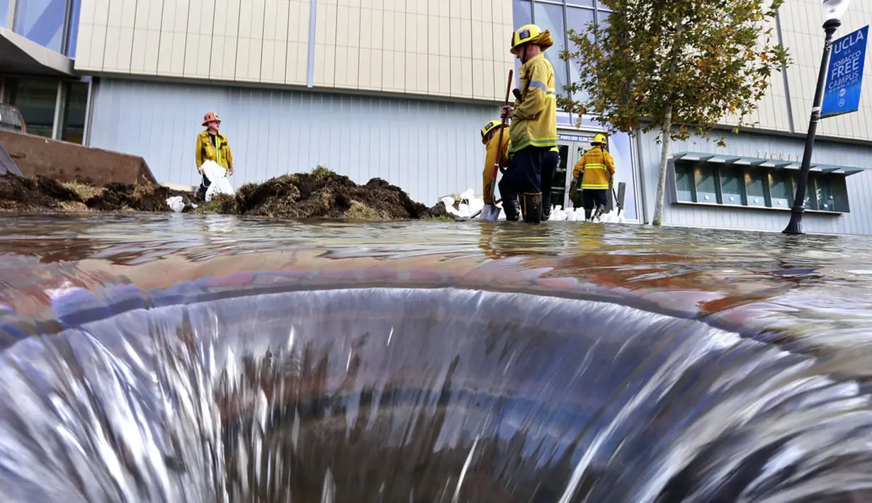 Beberapa petugas pemadam kebakaran berusaha mengatasi kerusakan pipa utama saluran air bawah tanah di sekitar Sunset Boulevard di bagian Westwood Los Angeles, (29/7/2014). (REUTERS/Jonathan Alcorn)