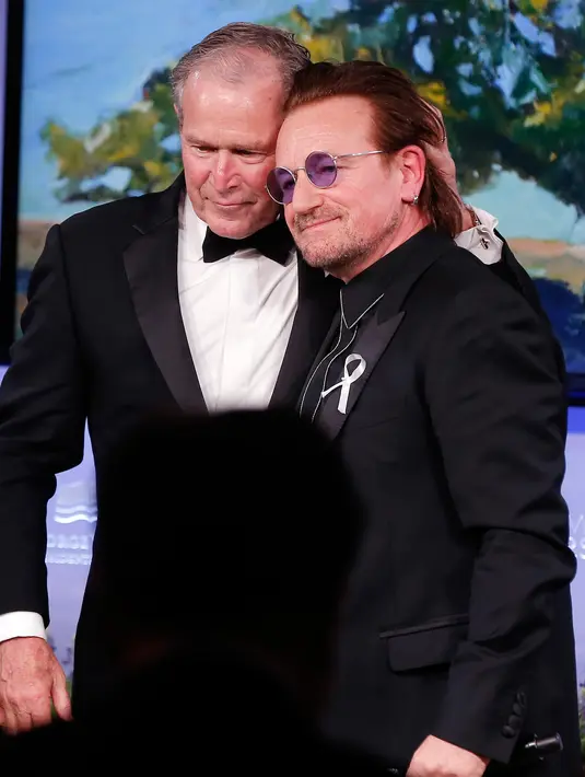 Presiden AS ke-43 George W. Bush berpose dengan vokalis U2 Bono selama gala untuk Forum Kepemimpinan di Institut George W. Bush di Dallas, AS (19/4). Dalam acara ini Bush mempersembahkan Bono medali Distinguished Citizenship. (AP Photo/Brandon Wade)