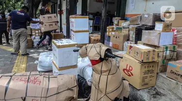 Pegawai jasa ekspedisi mengecek barang yang akan dikirim ke daerah di Pasar Senen, Jakarta Pusat, Selasa (5/5/2020). Barang tersebut akan dibawa ke Stasiun Barang Kampung Bandan untuk dibawa ke daerah-daerah di Jawa Tengah dan Jawa Timur dengan menggunakan kereta. (Liputan6.com/Faizal Fanani)