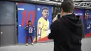 Seorang fans berfoto dengan memegang jersey Neymar Jr di depan toko merchandise di Paris, Jumat (4/8/2017). Setelah resmi bergabung dengan Paris Saint Germain, jersey Neymar Jr langsung diburu suporter klub Ibu kota. (AP/Kamil Zihnioglu)