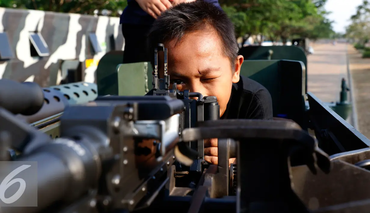 Anak-anak tampak senang memainkan senjata ketika menaiki Panser Anoa dalam pameran road to campus Alat Utama Sistem Persenjataan (Alutsista) di kawasan Boulevard Universitas Indonesia, Depok, Jawa Barat, Kamis (27/8/2015). (Liputan6.com/Yoppy Renato)