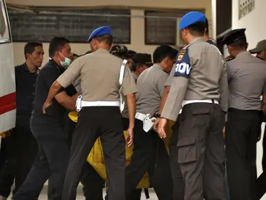 Petugas kepolisian membawa kantong jenazah masuk ke ruang jenazah di RS Bhayangkara Palu, Sulawesi Tengah, Selasa (17/7). Dua jenazah diduga teroris Santoso alias Abu Warda dan Muhtar yang tewas dalam baku tembak itu akan diidentifikasi. (OLAGONDRONK/AFP)