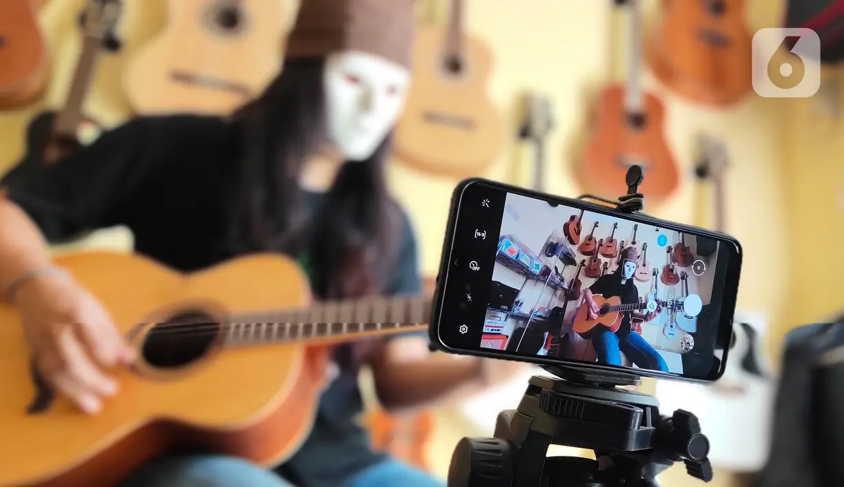 Pemilik showroom dan bengkel Gitar "music666", Ridwan dan Rudi mendemonstrasikan gitar yang akan dijual secara daring di Ciledug, Tangerang, Rabu (22/7/2020). Pemerintah menargetkan 10 juta usaha mikro kecil menengah (UMKM) pada tahun ini terhubung dengan platform digital (Liputan6.com/Angga Yuniar)