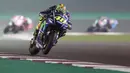 Pebalap Movistar Yamaha, Valentino Rossi, memacu motornya saat MotoGP Qatar. Meski memulai start dari posisi ke-10, namun The Doctor berhasil meraih podium dengan finish di urutan ketiga. (AFP/Karim Jaafar)