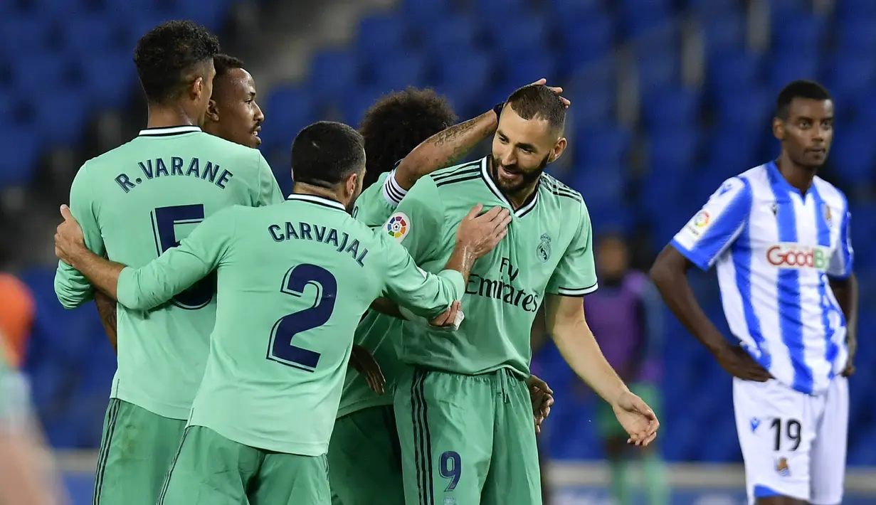 Para pemain Real Madrid merayakan gol yang dicetak oleh Karim Benzema ke gawang Real Sociedad pada laga La Liga di Reale Seguros Stadium, Minggu (21/6/2020). Real Madrid menang 2-1 atas Real Sociedad. (AP Photo/Alvaro Barrientos)
