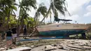 Sejumlah orang berjalan menghampiri sebuah kapal yang terhempas ke daratan akibat tersapu badai Irma di Coconut Grove, Florida, Senin (11/9).Badai Irma menghantam negara bagian Florida dengan kecepatan angin mencapai 200 km/jam. (SAUL LOEB/AFP)