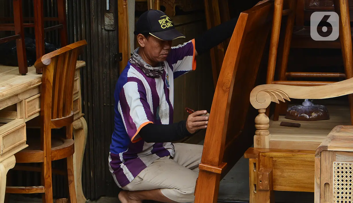 Pekerja melakukan proses finishing pembuatan furnitur atau perlengkapan rumah berbahan kayu khas Jepara di Ciputat, Tangerang Selatan, Selasa (14/9/2021). Pedagang di tempat tersebut mengakui selama PPKM ini daya beli masyarakat terhadap furnitur meningkat. (Liputan6.com/Johan Tallo)