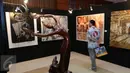 Pengunjung melihat karya seni lukis dan patung pada pameran amal Mandiri Art Charity di Jakarta, Sabtu (23/7). Pameran amal ini akan didedikasikan untuk pengembangan pendidikan anak bangsa dan seni di tanah air. (Liputan6.com/Angga Yuniar)