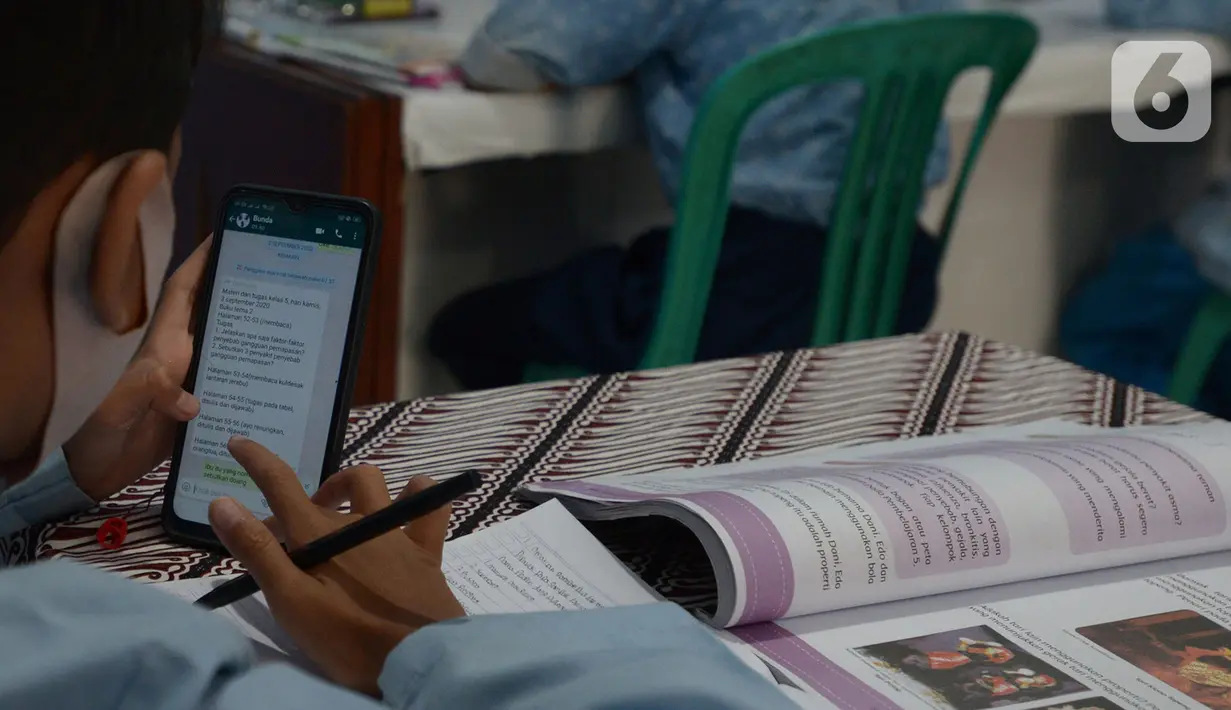 Pelajar saat kegiatan pembelajaran Jarak Jauh (PJJ) dengan memanfaatkan Jak Wifi di Balai Warga RW 02 Kelurahan Galur, Jakarta, Jumat (4/9/2020). Program internet gratis dari Pemprov DKI itu untuk pelajar di permukiman padat penduduk yang kesulitan mengakses internet. (merdeka.com/Imam Buhori)