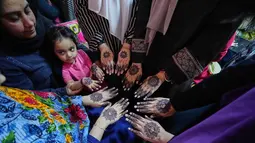 Sehari sebelum Idul Fitri merupakan puncak penggunaan henna bagi masyarakat Pakistan. Tampak dalam foto, para wanita memperlihatkan tangan mereka yang dihiasi dengan 'Henna' tradisional menjelang perayaan Idul Fitri, yang menandai berakhirnya bulan suci Ramadan, di Rawalpindi, Pakistan, Rabu, 18 Maret 2026. (AP Photo/Anjum Naveed)