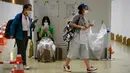 Jurnalis yang mengenakan masker untuk mencegah penularan COVID-19 tiba untuk memberikan sampel air liur harian saat tes PCR di Pusat Media Olimpiade Tokyo 2020, Tokyo, Jepang, 20 Juli 2021. Para jurnalis wajib mengikuti tes usap PCR setiap hari sesuai permintaan pemerintah Jepang. (Franck FIFE/AFP)