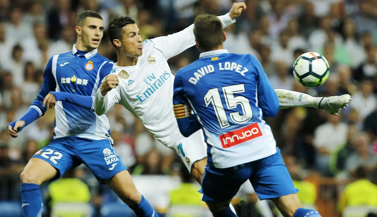 Bintang Real Madrid, Cristiano Ronaldo (tengah) melepaskan tembakan melewati adangan pemain Espanyol pada laga La Liga Santander di Santiago Bernabeu stadium, Madrid, (01/10/2017). Real Madrid menang 2-0. (AP/Paul White)