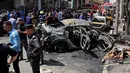 Pasukan keamanan Irak dan warga sipil memeriksa lokasi serangan bom di Baghdad, Irak (30/5). Lewat media propaganda Amaq, ISIS menyatakan bahwa pengebom bunuh diri tersebut menargetkan warga Syiah. (AP Photo / Karim Kadim)